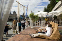 The Paris Plage urban beach. People strolling between the River Seine and other people lying on whicker chairs along the Voie Georges Pompidou usually a busy road  now closed to traffic opposite the I...