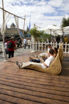 The Paris Plage urban beach. People strolling between the River Seine and other people lying on whicker chairs along the Voie Georges Pompidou usually a busy road  now closed to traffic opposite the I...