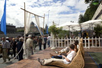 The Paris Plage urban beach. People strolling between the River Seine and other people lying on whicker chairs along the Voie Georges Pompidou usually a busy road  now closed to traffic opposite the I...