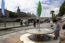 The Paris Plage urban beach. A small boy at one of the many free drinking water fountains on the Voie Georges Pompidou  a usually busy road closed to traffic  opposite the Ile de la Cite