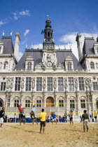 The Paris Plage urban beach. Young people playing beach volleyball in front of the Hotel de Ville Town Hall