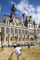 The Paris Plage urban beach. Young people playing beach volleyball in front of the Hotel de Ville Town Hall