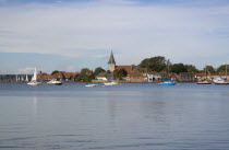 View across water toward Old Bosham with the church spire visibleGreat Britain UK United Kingdom