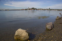 View across water toward Old Bosham with the church spire visibleGreat Britain UK United Kingdom