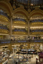 Opera Quarter. The central circular area under the glass dome of the Art Nouveau department store Galleries Lafayette showing the balconies and the perfume department on the ground floorShop European...