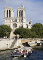 A bateaux mouches vedette pleasure boat on the River Seine taking sightseers past Notre Dame Cathedral on the Ile de la CiteEuropean French Religion Western Europe