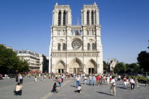 Tourists in the suare at the west front of the Gothic style Notre Dame Cathedral on Ile de la CiteEuropean French Religion Western Europe