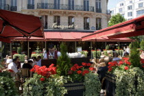 Fouquets brasserie on the Champs Elysees with waiter and customers at pavement tables under sun shade umbrellasEuropean French Western Europe