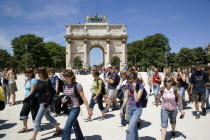 Students walking past the 19th Century Arc de Triomphe du Carrousel at the entrance to the Tuileries gardens beside the Louvre MuseumKids European French Western Europe