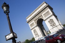 Traffic around the Arc de Triomphe in Place Charles de Gaulle with a street sign on a lamp postEuropean French Western Europe