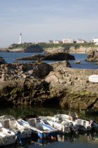 The Basque seaside resort on the Atlantic coast. Boats in the safe harbour of the Port des Pecheurs with the lighthouse in the distance.