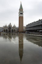 Aqua Alta High Water flooding in St Marks Square with St marks Basilica and the Campanile reflected in the flooded piazza