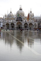 Aqua Alta High Water flooding in St Marks Square with St Marks Basilica at the far end of the flooded piazza