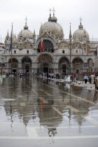 Aqua Alta High Water flooding in St Marks Square showing St Marks Basilica at the end of the flooded piazza