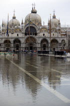 Aqua Alta High Water flooding in St Marks Square showing St Marks Basilica at the end of the flooded piazza