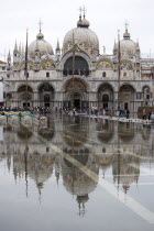 Aqua Alta High Water flooding in St Marks Square showing St Marks Basilica at the end of the flooded piazza