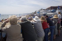 Tourists watching speedboat races off the West Beach with the Oceanarium and BICC Bournemouth International Conference Centre on the right