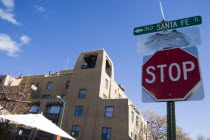 Stop sign on the Old Santa Fe Trail beside an adobe Pueblo Revival style building