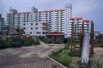 Large apartment block and childrens playground in east coast fishing port.