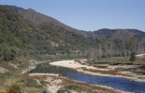 Bend in river through steep sided valley floor.