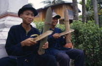 Young musicians playing bamboo instruments.