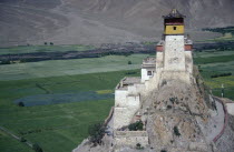 Hilltop monastery with agricultural land and lower mountain slopes spread out below.