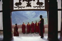 Monks on the balcony overlooking the valley below