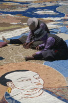 Potola Palace.  Workers sewing huge Buddha Tankha spread out on floor. thangka