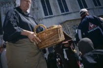 Street performer carrying basket during outdoor play in Burg Square Flemish Region