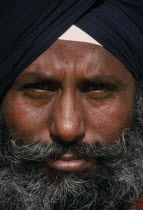 Portrait of man with grey beard and black turban