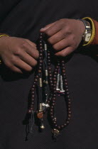 Close view of hands holding prayer beads.