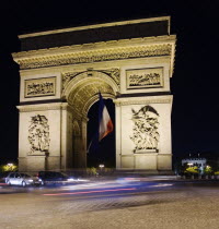 The Arc de Triomphe illuminated at night with the French tricolour flkag flying from the central arch and traffic cirlcling the Arc in the Place de Charles de GaulleFrench Western Europe European