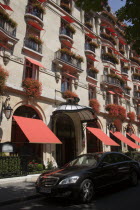 The facade of the five star Hotel Plaza Athenee on the Avenue Montagne in the heart of the haute couture fashion district with red geraniums in window boxes and red awningsFrench Western Europe Europ...