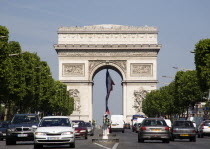 Traffic in the Champs Elysees leading to the Arc de Triomphe in Place de Charles de Gaulle with the French tricolour hanging from the central arcFrench Western Europe European