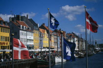 Nyhavn canal with colourful houses along the harbour front. Flags flying in the foreground.Colorful Danish Danmark European Northern Europe Scandinavia