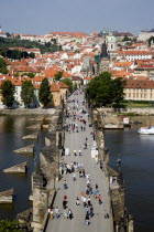 People walking across the Charles Bridge across the Vltava River towards the Little QuarterPraha Ceska Eastern Europe European