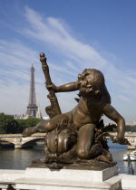 Bronze statue of a cherub on the Pont Alexandre III bridge across the River Seine with the Eiffel Tower in the distance European French Western Europe