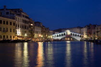 The Rialto Bridge illuminated at night spanning the Grand Canal