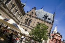 People seated at tables under umbrellas at an outdoor cafe in Prague castle beside St Georges Convent in HradcanyPraha Bar Bistro Ceska Eastern Europe European Religion Restaurant