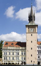 Restaurant with umbrellas over tables on the pavement beside a clock tower in The Old Town on the banks of the Vltava RiverPraha Ceska Eastern Europe European