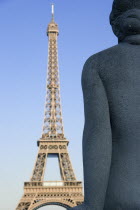 Stone sculpture of a seated woman in the Trocadero Gardens with the Eiffel Tower in the distanceEuropean French Western Europe