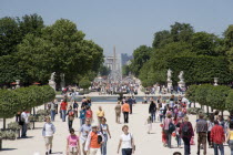 Tourists walk through the Jardin desTuileries towards the Champs Elysees and the Arc de Triomphe in the distanceEuropean French Western Europe