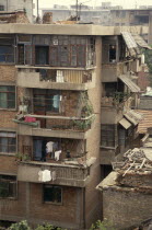 Housing block with potted plants and drying clothes on the balconies.