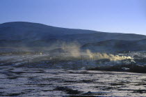 Drifting smoke from buildings in landscape with light covering of snow in March sunset.Asia Asian Mongol Uls Mongolian Scenic