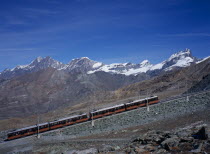 Gornegrat Railway with train traveling past snow capped mountains left to right  Oberrothorn 3414metres    11180ft    and Fluehorn 3317metres   10863ft  European Schweiz Suisse Svizzera Swiss Wester...