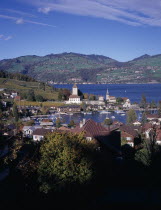 View across trees and roof tops towards Spiez Village and the south bank of Lake Thunersee with yachts on the waterEuropean Schweiz Suisse Svizzera Swiss Western Europe Scenic