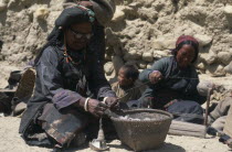 Women spinning thread with one wearing head dress displaying turquoise heirloomAsia Asian Female Woman Girl Lady Nepalese Female Women Girl Lady 1 One individual Solo Lone Solitary Single unitary