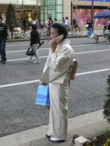 Ginza - woman  over 50 yeras old  dressed in kimono  using cell phoneAsia Asian Japanese Nihon Nippon Female Women Girl Lady Female Woman Girl Lady