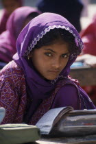 A young girl student dressed in purple sitting at a desk with books at the mosque school in the Dargah Hazrat Qamruddin Shah SahibAsia Asian Nepalese Bharat Inde Indian Intiya Male Men Guy Male Man G...