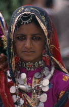 Portrait of a young tribal woman wearing traditional dress and jewellery before the start of the Camel FestivalAsia Asian Nepalese Bharat Classic Classical Female Women Girl Lady Historical Inde Indi...